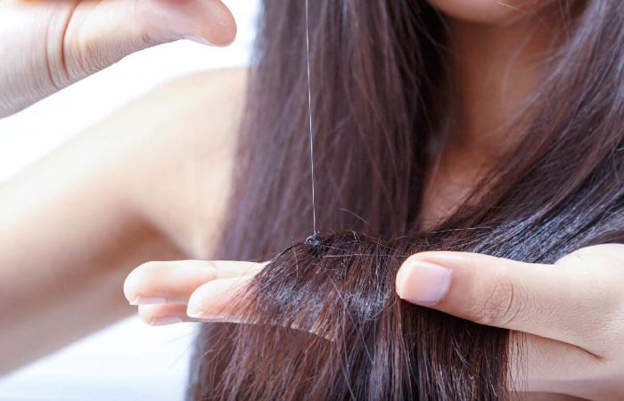 Diffuser Haarausfall – Ursachen, Verlauf und Diagnose 10 Frau analysiert ihre Haare auf möglichen Haarausfall