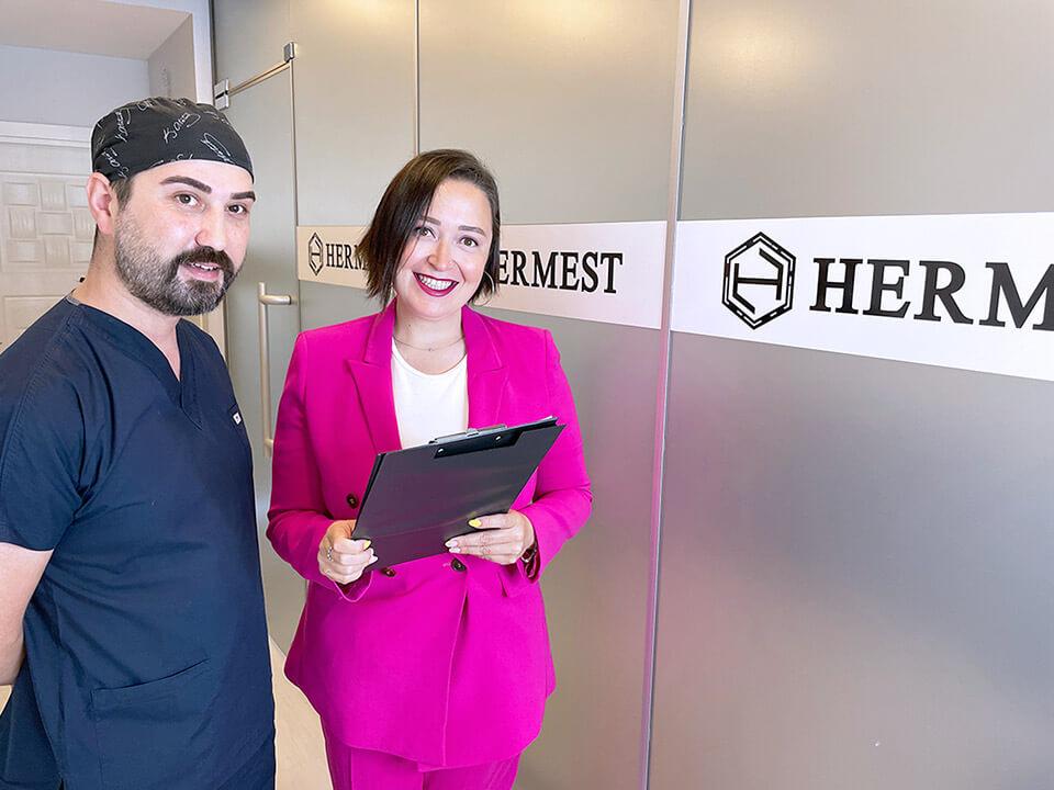 2 Mitarbeiter der Hermest Hair Clinic stehen in der Klinik und lächeln