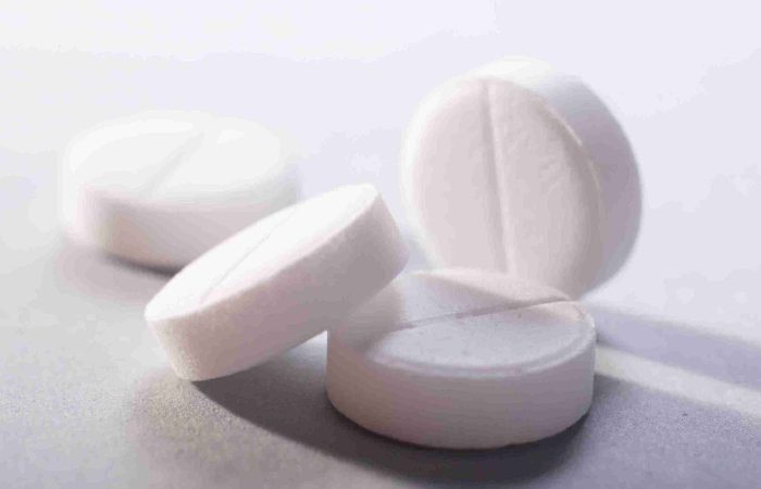 Aspirin für die Haare – Wundermittel oder nur Gerüchte? 12 Weiße Aspirin Tabletten als Symbol für die Anwendung von Aspirin für die Haare gegen Schuppen, Verfärbungen und Haarausfall.