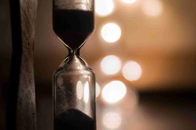Eine Sanduhr mit herabfließendem Sand symbolisiert den Lauf der Zeit – sinnbildlich für die Frage, wann Haartransplantation zu spät ist.