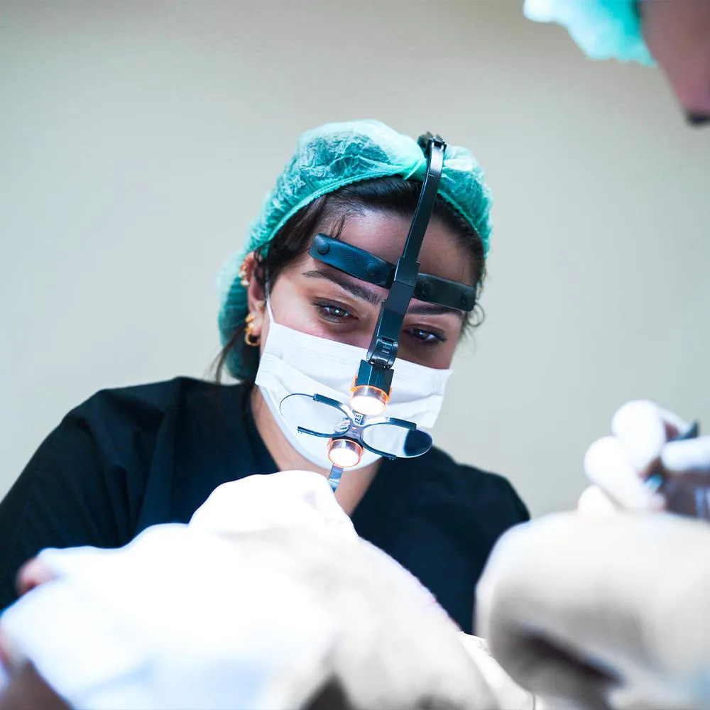 Spécialiste Hermest réalisant une greffe Sapphire FUE avec des loupes chirurgicales