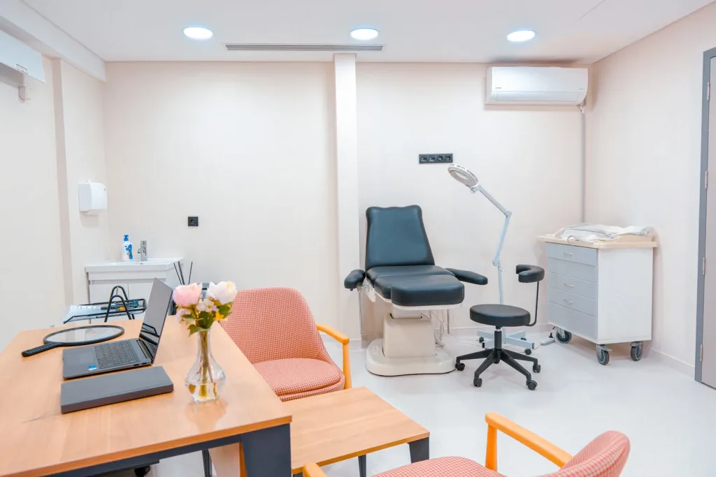 Untersuchungsraum mit Behandlungsstuhl und Untersuchungsleuchte in der Hermest Hair Clinic