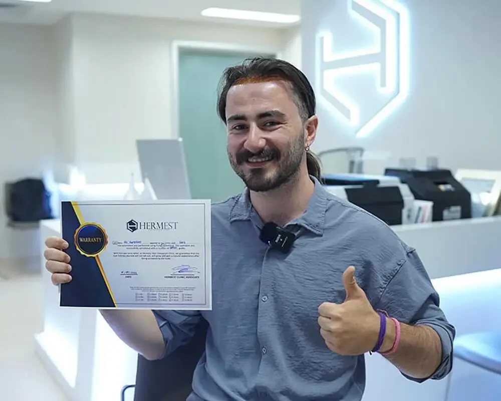 Patient souriant présentant son certificat Hermest à la réception de la clinique