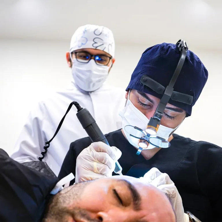 Specialista che preleva gli innesti con un micromotore mentre un medico in camice bianco osserva