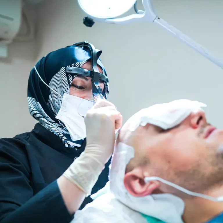 Chirurgienne en foulard avec loupes préparant le cuir chevelu d'un patient allongé