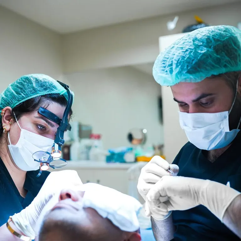 Specialista con lenti d'ingrandimento e chirurgo durante un trapianto di capelli