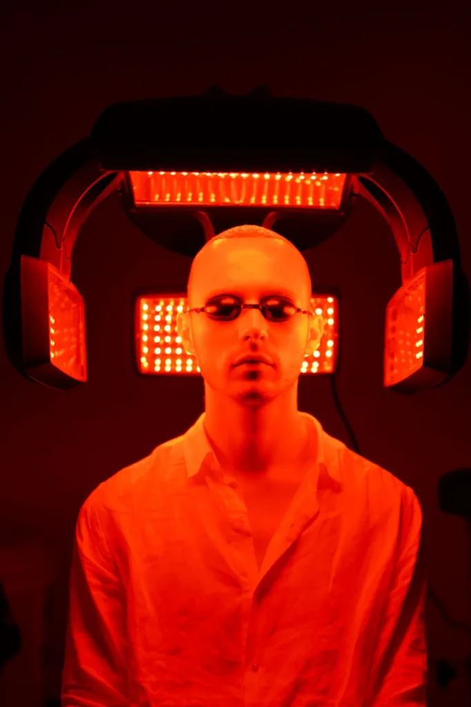 Paziente con occhiali protettivi durante una seduta di terapia con luce LED rossa
